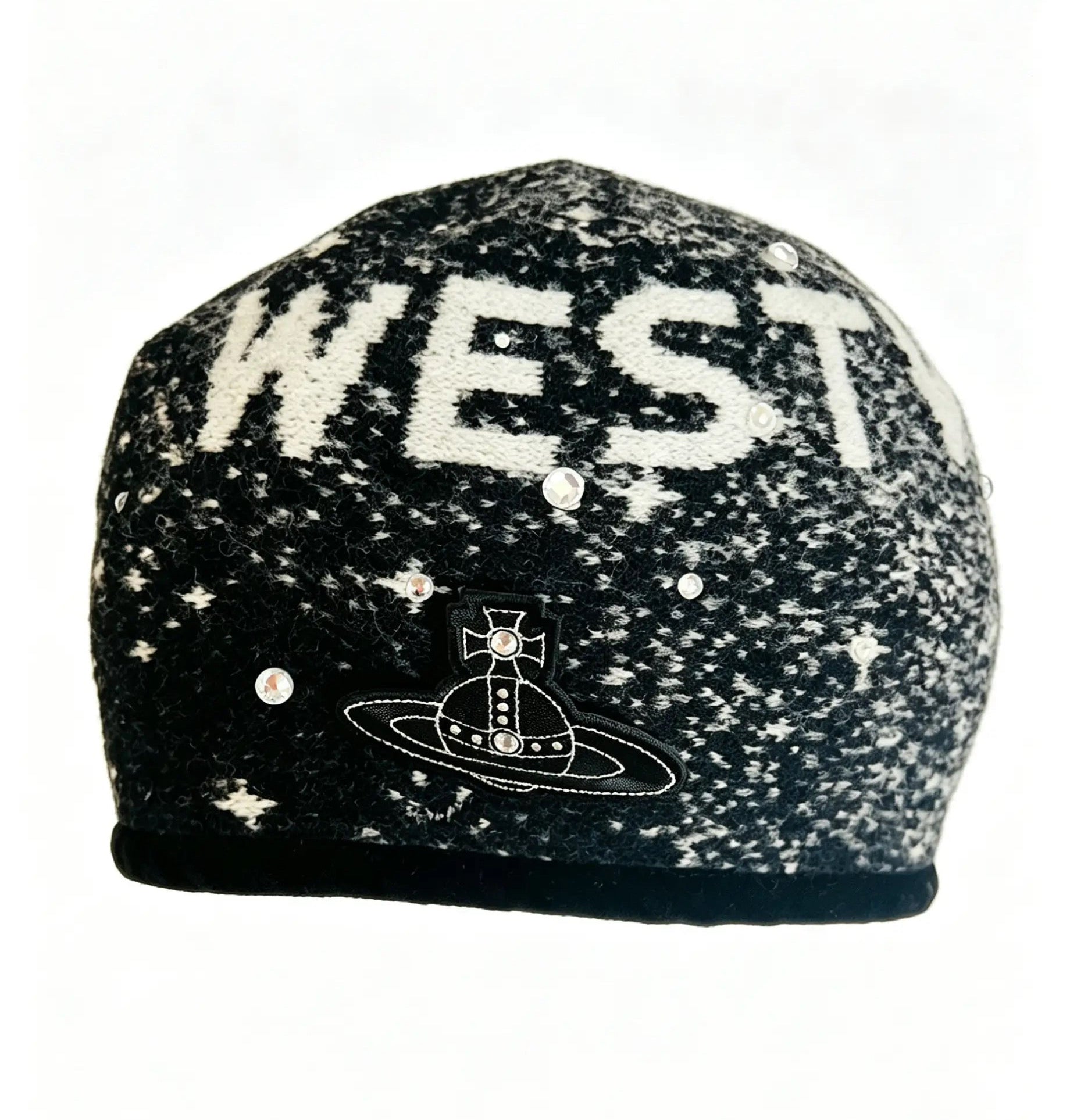 A knit beanie hat featuring a black and white speckled space pattern with the word 'WEST' in large white letters and a Saturn graphic below it, shown against a plain white background.