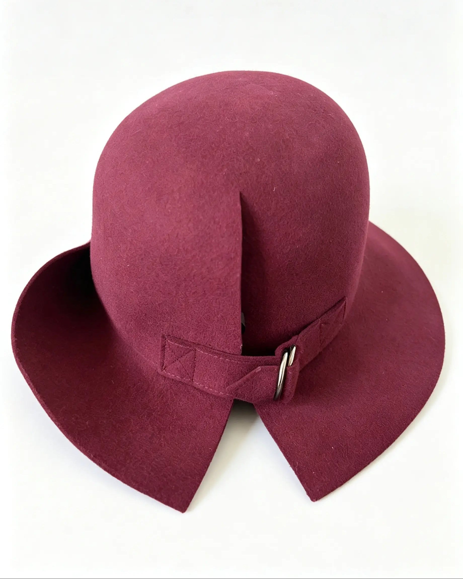 A burgundy felt cloche hat with a wide brim and a matching ribbon detail on the back, photographed against a plain white background.